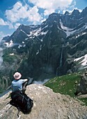 Spaziergänger, der sich ausruht und die Aussicht über den Cirque De Gavarnie auf den höchsten Wasserfall Europas bewundert
