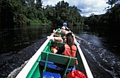 Touristen im Schnellboot auf dem Fluss durch den Dschungel