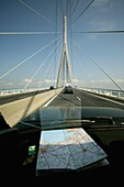 Frankreich, Normandie-Brücke; Normandie, Auto überquert moderne Brücke mit französischer Karte auf dem Armaturenbrett