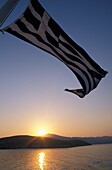 Griechische Flagge über dem Meer bei Sonnenaufgang