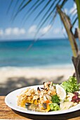 Krabben und Salat auf einem Tisch am Strand