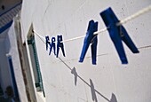 Washing Line Against House With Blue Clothes Pins