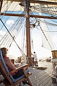 Woman Sitting In Chair Watch Crew Member Work The Sails