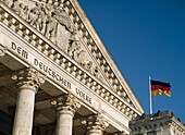 Detail des Bundestages (Reichstag) mit deutscher Flagge im Vordergrund