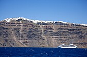 Kreuzfahrtschiff neben Santorini