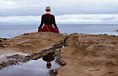 Buddhistische Nonne meditiert an der Küste