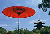 Roter Regenschirm mit Tempel dahinter, Nahaufnahme