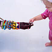 Maasai Passing A Young Child A Shell, Close Up