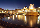 Fountains In Trafalgar Square Looking Across To The National Portrait Gallery At Dusk