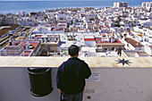 Mann blickt über Stadt und Küste in Cadiz