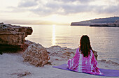 Woman Looking Out Across Sea From Beach