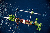 Mann und Frau in traditionellem Outrigger-Kanu, Luftaufnahme