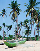 Zwei leere Liegestühle und ein Strohschirm am Strand von Nilaveli