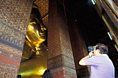 Tourist filmt riesige liegende Buddha-Statue im Wat Po-Tempel
