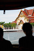 Tourists On Boat On Chao Phraya River Passing Grand Palace
