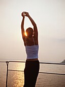 Westliche Frau beim Yoga auf einem Kreuzfahrtschiff