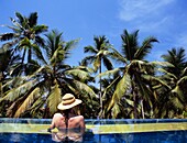 Woman With Straw Hat Relaxing In Swimming Pool