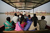 Indische Touristen fahren auf einem Boot zum Neermahal-Palast und See