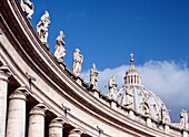 Statuen über dem Säuleneingang zur Piazza San Pietro mit dem Petersdom im Hintergrund, Vatikanstadt