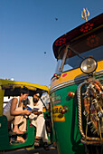 Tourist sieht Reiseführer mit Sikh-Rikscha-Fahrer an