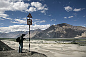 Tourist With Camera On High Altitude Desert At Hundar