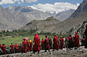 Buddhist Monks Walking In A Crowd With Snow Capped Peaks