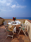 Empty Breakfast Table And Chairs On Balcony Overlooking The Ocean