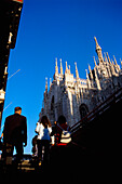 Low Angle View Of Pedestrians And Duomo
