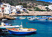 View Over Water At Small Boats And Local Architecture On Levanzo Island.