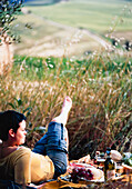 Frau entspannt sich beim Picknick im Feld