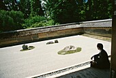 Sitzende Person neben dem Garten des Abtes von Ryoanji