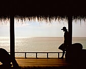 Woman On Porch Overlooking Ocean