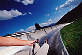 Person Sliding Down A Dry Tobaggan In The Summer