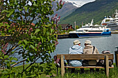 A Couple Of Old Ladies Sitting On Bench By Cruise Ships