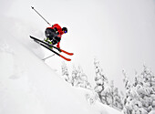 Ein Skifahrer bekommt ein wenig Luft beim Skifahren bergab in der Eaglecrest Ski Area in Juneau, Alaska