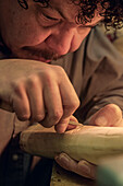 Elfenbeinschnitzer aus Alaska bei der Arbeit an einem Stück Ak Studio/Njohn Koschman