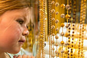 Young Girl Looking At Gold Jewellery For Sale In Window Of Shop In The Gold Souk; Dubai, United Arab Emirates