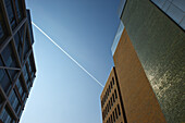 Niedriger Blickwinkel auf Gebäudefassaden vor einem blauen Himmel mit einem Jetstream; Hamburg, Deutschland