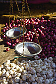 Waage zum Wiegen neben Haufen von Knoblauch und roten Zwiebeln; Ulpotha, Embogama, Sri Lanka