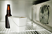 Empty Interior Of A Commercial Stainless Steel Refrigerator With Only A White Chinese Take Out Box And A Bottle Of Beer; Montreal, Quebec, Canada