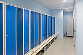 Sports and exercise facilities indoors in a gym, changing rooms, lockers with blue doors. 