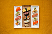 Sushi platter, a selection of raw fish and rice snacks with chopsticks. 