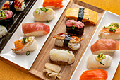 Sushi platter, a selection of raw fish and rice snacks with chopsticks. 