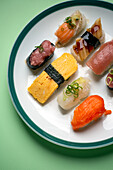 Sushi platter, a selection of raw fish and rice snacks with chopsticks. 