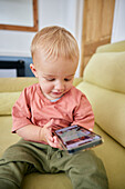 Toddler looking at smart phone indoors