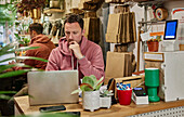 Man using laptop on shop counter