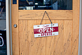 Ein Schild "Open" an der Tür eines Restaurants. -
