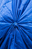 Close up of a tarpaulin cover, knotted with pleated pattern. 