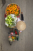 Straßenverkäufer mit runden Obstkörben auf dem Fahrrad, Altstadt, Hanoi, Vietnam