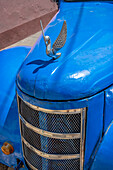 Detail of classic blue American car with chrome swan hood ornament in Trinidad, Cuba.